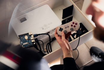 Eine Hand hält einen Controller von einer alten Spielekonsole fest